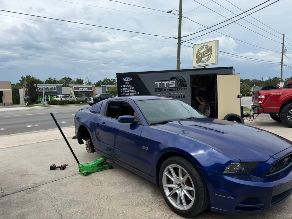 Mustang with its tire off being repaired on the roadside by Taylor Mobile Tire Service in Ocala, Florida